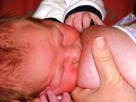 Bebé adquiriendo las bacterias de la leche materna.